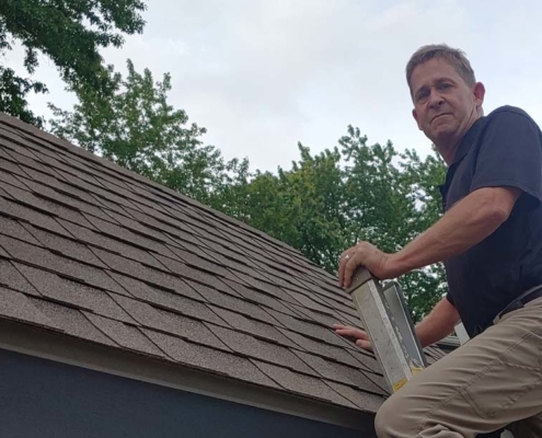 Steve on ladder checking out the roof